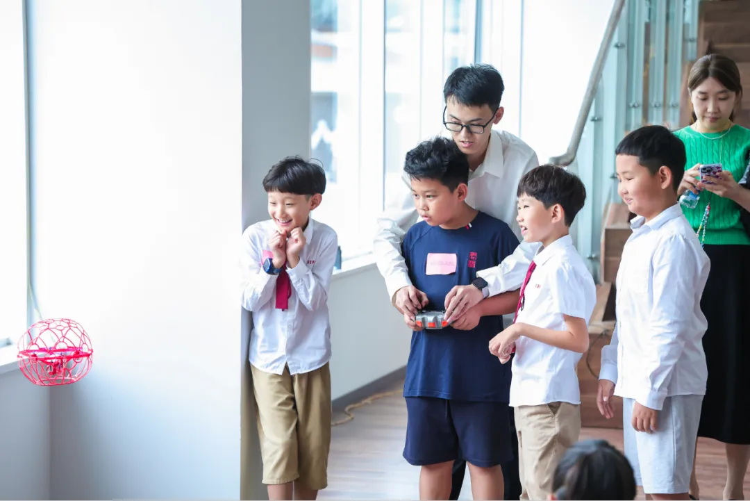 无人机飞行:孩子们仰望上方,观看无人机在大楼内自由飞翔。