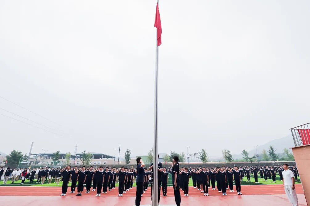 在庄严的升国旗仪式中,全体师生肃立凝视,齐声高唱国歌