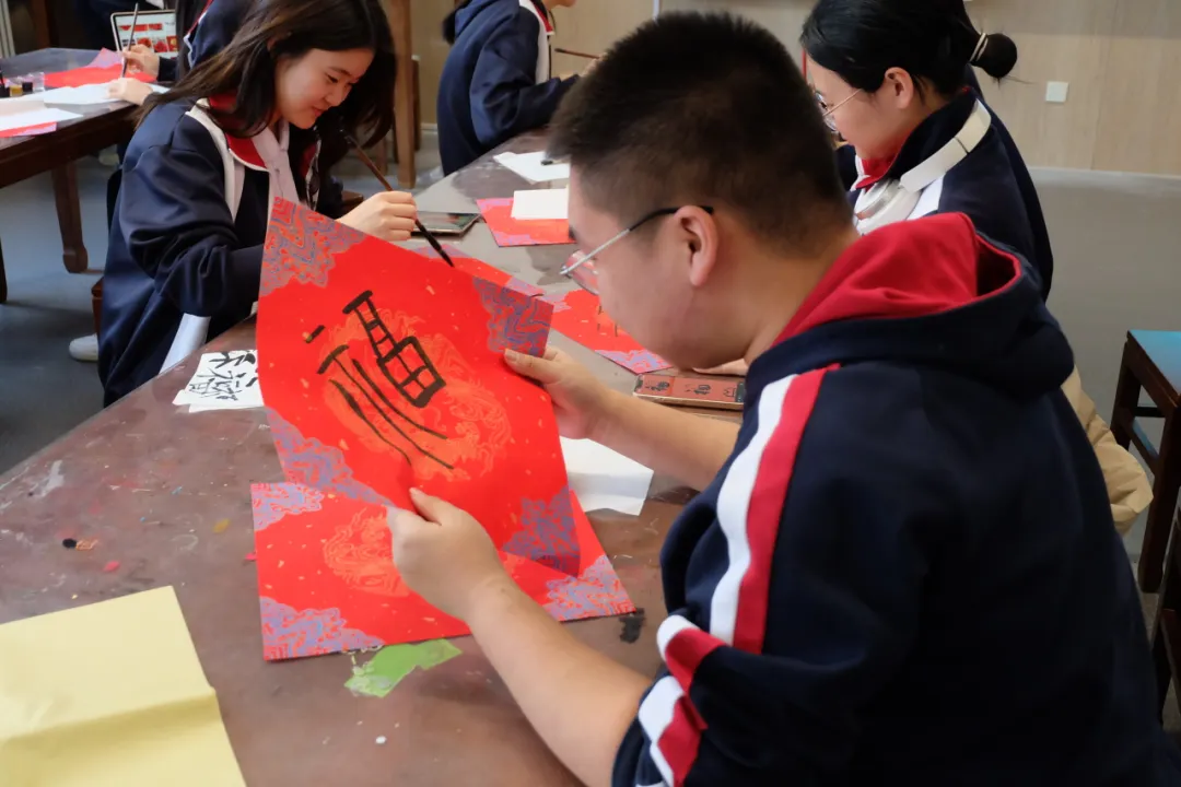 活动接近尾声,同学们小心卷起红纸,将亲手写的福字与对联收进书包。
