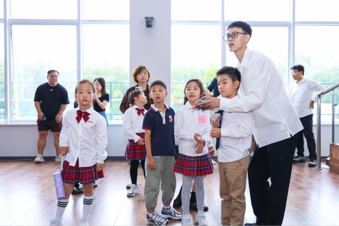无人机飞行:孩子们仰望上方,观看无人机在大楼内自由飞翔。(图 5)